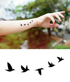 a woman's arm with birds drawn on it