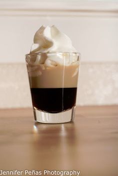 a glass filled with liquid and whipped cream