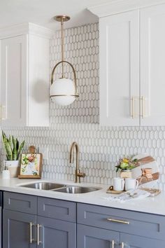 a white and blue kitchen with gold accents