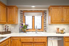 a kitchen with wooden cabinets and white marble counter tops, an open window above the sink