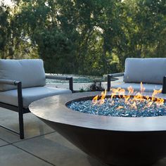 an outdoor fire pit with chairs around it