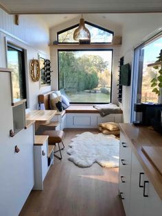 the interior of a tiny home with lots of windows and storage space on each side