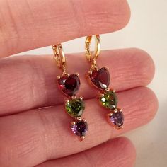 Beautiful Women's "Trilogy Design" Multi Color Heart Shape Zircon Dangle Party Earrings 18k Yellow Gold Filled W/ Heart Shape Garnet Red, Peridot Green, + Amethyst Purple Simulated Diamond Topaz Zircon Gemstones. Top Quality, High Polished Shine, Brand New, Never Been Worn. Lead, Nickel Free. These Gorgeous Earrings Sparkle. The "Trilogy" Design Represents Different Things To Different People - Past, Present, And Future, Relationships, Three Years Together, Three Special People. Perfect Jewelry Heart Diamond Earrings, Minnie Mouse Earrings, Garnet Red, Color Heart, Crystal Jewelry Sets, Peridot Green, Zircon Jewelry, Heart Dangle Earrings, Gold Jewellery Design Necklaces