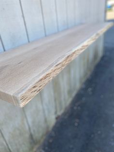 a close up of a wooden bench on the side of a building with wood planks