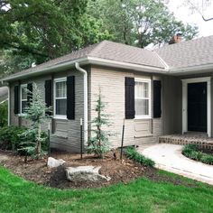 a small gray house with black shutters