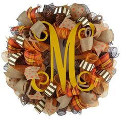 a wreath with the letter m on it's front and side is decorated with orange, yellow and brown ribbons