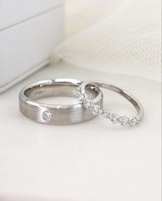 two wedding rings sitting on top of each other