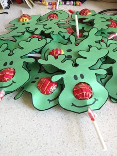 green paper cutouts with candy sticks sticking out of them