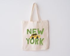 Designed for you to show off some New York City pride! This 100% natural canvas tote features Aleisha's original hand-illustrated font spelling out "New York," cleverly placing an infamous yellow taxi cab in between the two words! Screen-printed onto ethically sourced fabric. Run errands with it, carry your groceries home in it, bring it to the beach, take it along to the Farmer's Market, or give it out to your bridal party or group of best friends-- perfect for so many occasions! Yellow Taxi Cab, New York Taxi, Nyc Christmas, Yellow Taxi, Taxi Cab, Farmer's Market, Canvas Designs, Bring It, Christmas Market