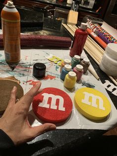 a person is making decorated cookies on a table with paint and other crafting supplies