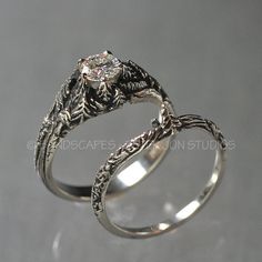 two silver rings with an intricate design on each side and a diamond in the middle