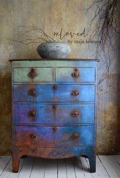 an old dresser painted blue and purple with a bowl on top