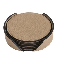 four round coasters stacked on top of each other in black and tan leather with contrasting stitching