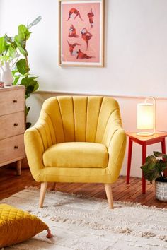 a living room with two yellow chairs and a white rug on the wooden flooring