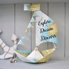 a sailboat made out of paper with the words explore dream discovery written on it