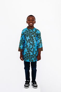 Ade - Crown Showcase your child's personal style with our Ade Ankara Print Boy's Shirt. Made with authentic African Ankara print, this shirt embraces culture and heritage while keeping your little one on-trend as a style icon. The perfect choice for the fashion-forward trendsetter. FEATURES:     High neck     3/4 sleeve      Half Button up     Comfort fit     100% wax cotton Care Instructions: Hand wash or machine wash cold with mild detergent. Hang to dry. Iron on reverse side. Do not bleach. Do not iron on print. Disclaimer: The fabric patterns on each item may differ from the picture due to the unique nature of African fabrics. However, please be assured that it is cut from the same fabric as shown in the picture. Blue Long Sleeve Kurta With Batik Print, Blue Long Sleeve Top With Batik Print, Traditional Blue Batik Print Tops, Cotton Long Sleeve Shirt For Festivals, Long Sleeve Cotton Shirt For Festivals, Ankara Shirt, Boys Tops, Ankara Print, African Ankara