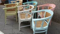 there are many different colored chairs on the street side line and one has a wicker seat