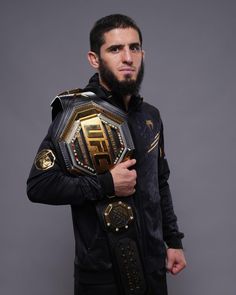 a man with a beard holding a wrestling belt