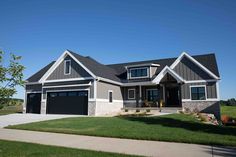 a large gray house with two garages on the front