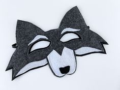 a black and white mask with a wolf's face on it, made out of felt