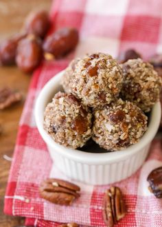 nuts and granola balls in a white bowl on a red checkered napkin