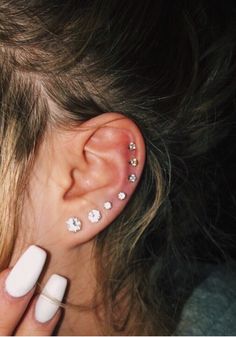 a close up of a person's ear with some piercings on top of it