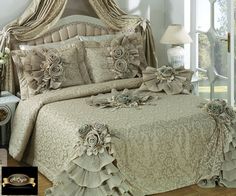 a large bed covered in lots of ruffles and flowers next to a window