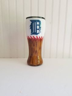 a close up of a wooden cup on a table with a wall in the background