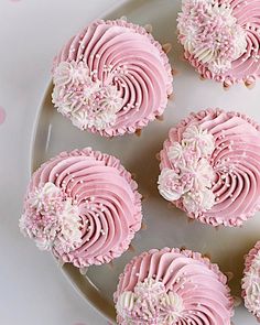 pink cupcakes with white frosting on a plate