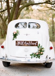 an old white car with flowers on the front