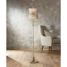 a lamp that is on top of a wooden floor next to a chair and wall