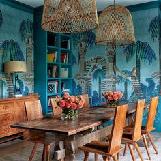 the dining room is decorated with tropical wallpaper and wicker chandeliers hanging from the ceiling