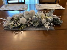 a wooden table topped with white and silver decorations