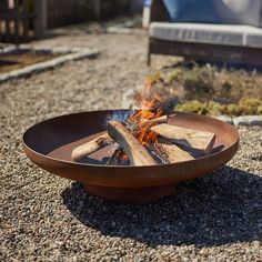 a fire pit sitting on top of gravel covered ground