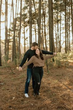 an engaged couple walking through the woods