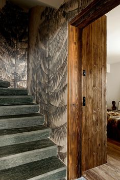 an open door leading to a bedroom next to a set of stairs