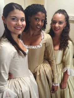 three women in dresses standing next to each other