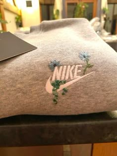 a pair of nike socks with blue flowers on them sitting on top of a table