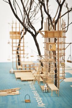 a group of wooden structures sitting on top of a blue floor next to a tree