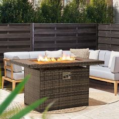 a fire pit sitting on top of a wooden table next to a couch and chair