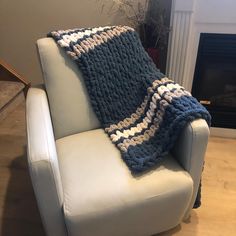 a blue and white crocheted blanket sitting on top of a couch