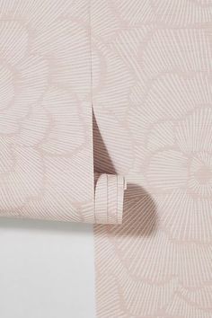 the corner of a pink wallpaper with an intricate design on it and a white background