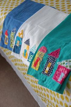 a close up of a pillow on a bed with polka dot sheets and colorful pillows