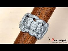 a close up of a knot on a wooden stick with the words paracord guide written below it