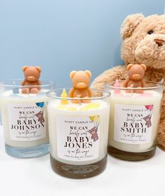 three candles sitting next to a teddy bear