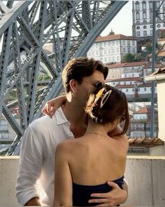 a man and woman standing on top of a bridge