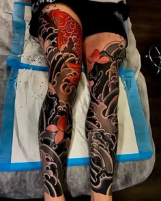 a person laying on top of a bed with lots of tattoos on their arms and legs