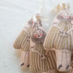 two small ornaments are sitting on the snow covered ground, one is wearing a dress and the other has a bow tie around it's neck