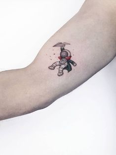 a person with a tattoo on their arm holding an object in one hand and the other