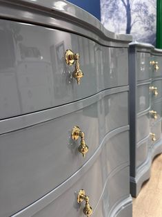 two gray dressers with gold handles and knobs